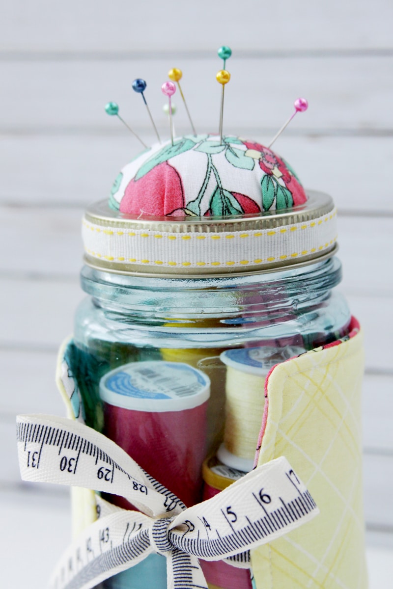Easy Embroidered Mason Jar Pincushion tutorial - so cute and such a great gift idea for the avid sewer! Grab your fabric, fusible fleece, ribbon, stuffing, and a few more supplies and you're ready to make this adorable gift!
