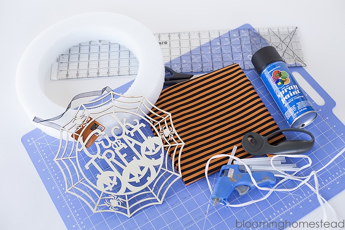 Supplies to make outdoor halloween wreath, laying out on a table.